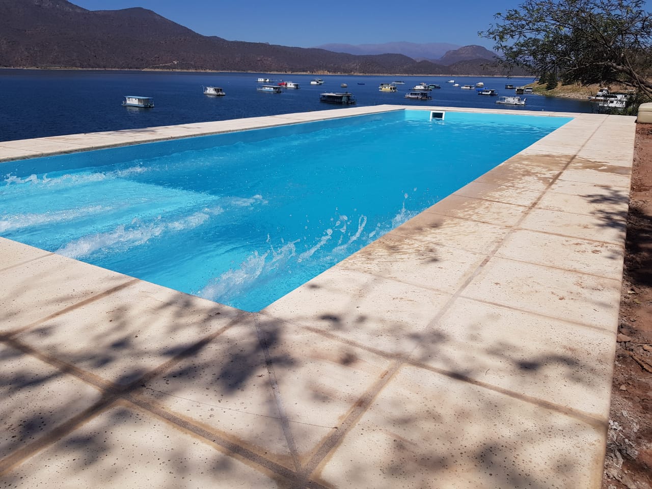 Piscina junto al agua y paisaje abierto