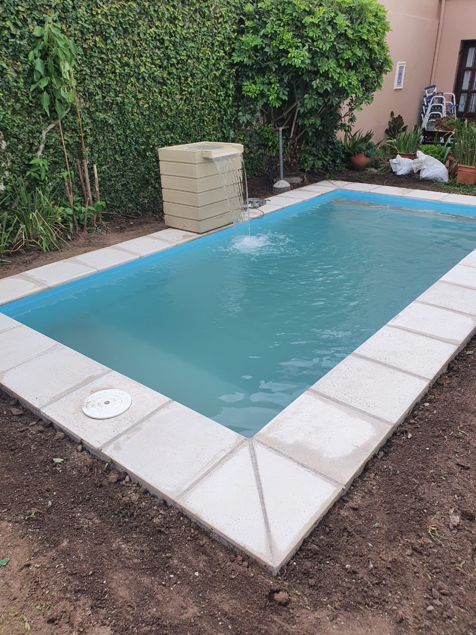Piscina con cascada y jardin