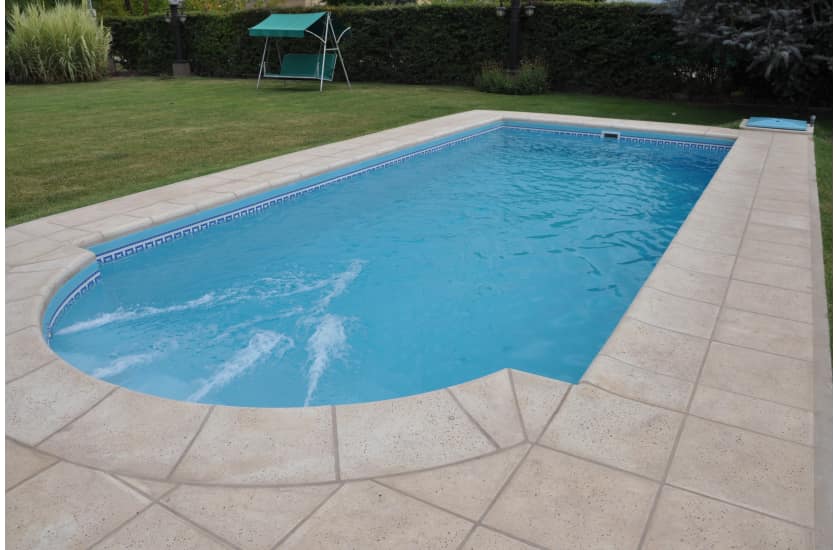 Piscina residencial con borde y jardin
