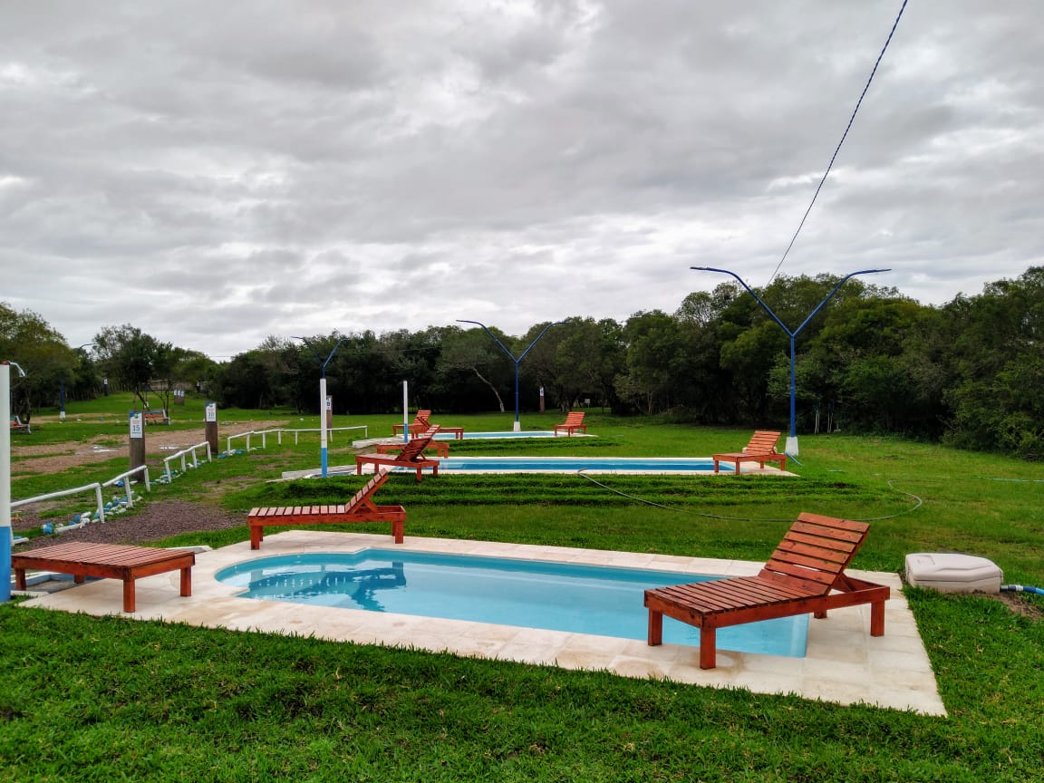 Complejo con piscinas y reposeras