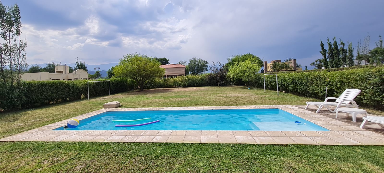 Piscina familiar con reposeras y juguetes